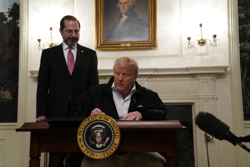 Donald Trump President Donald Trump signs an $8.3 billion bill to fight the coronavirus outbreak in the U.S., Friday, March 6, 2020 at the White House in Washington, as Department of Health and Human Services Secretary Alex Azar, looks on. The legislation provides federal public health agencies with money for vaccines, tests and potential treatments and helps state and local governments prepare and respond to the threat. The rapid spread of the virus has rocked financial markets, interrupted travel and threatens to affect everyday life in the United States. (AP Photo/Evan Vucci)