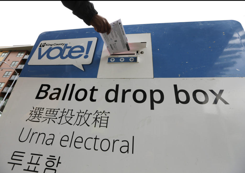 Voters drop off ballots in the Washington State primary, Tuesday, March 10, 2020 in Seattle. Washington is a vote by mail state. (AP Photo/John Froschauer)