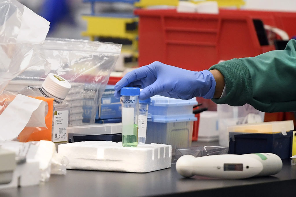 Virus Outbreak Connecticut A researcher moves a vial in a lab. Labs are ramping up their research, in the hopes of finding a vaccine for COVID-19. (Jessica Hill/AP Photo)
