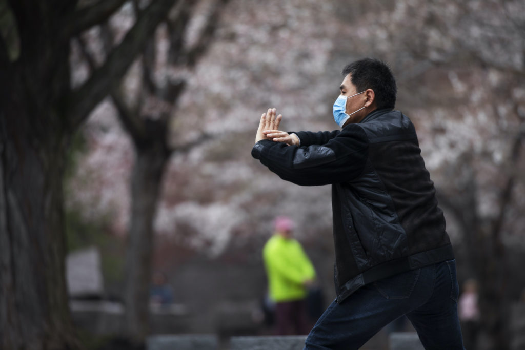 Zhili Sun Zhili Sun, practices tai chi by blooming cherry trees while wearing a mask along the tidal basin in Washington. (Jacquelyn Martin/AP Photo)