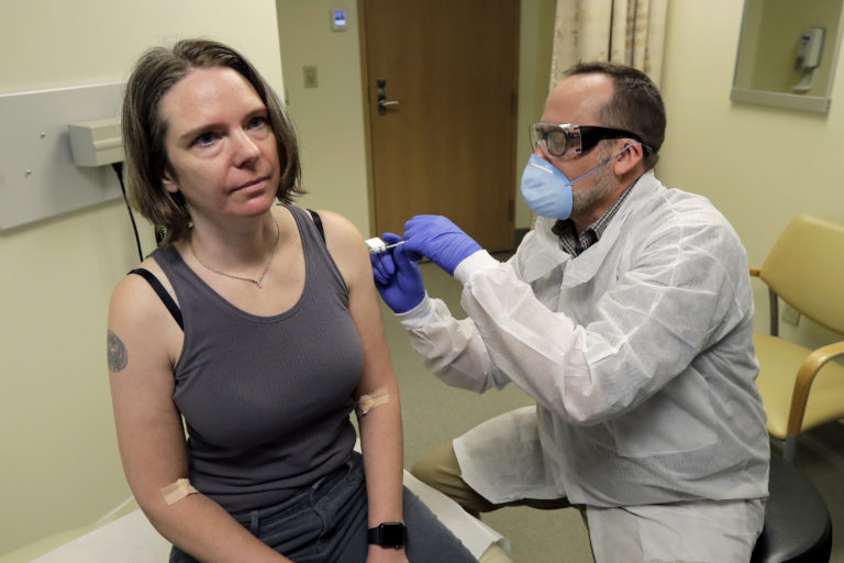 A pharmacist gives Jennifer Haller, left, the first shot in the first-stage safety study clinical trial of a potential vaccine for COVID-19, the disease caused by the new coronavirus, Monday, March 16, 2020, at the Kaiser Permanente Washington Health Research Institute in Seattle. (Ted S. Warren/AP Photo)