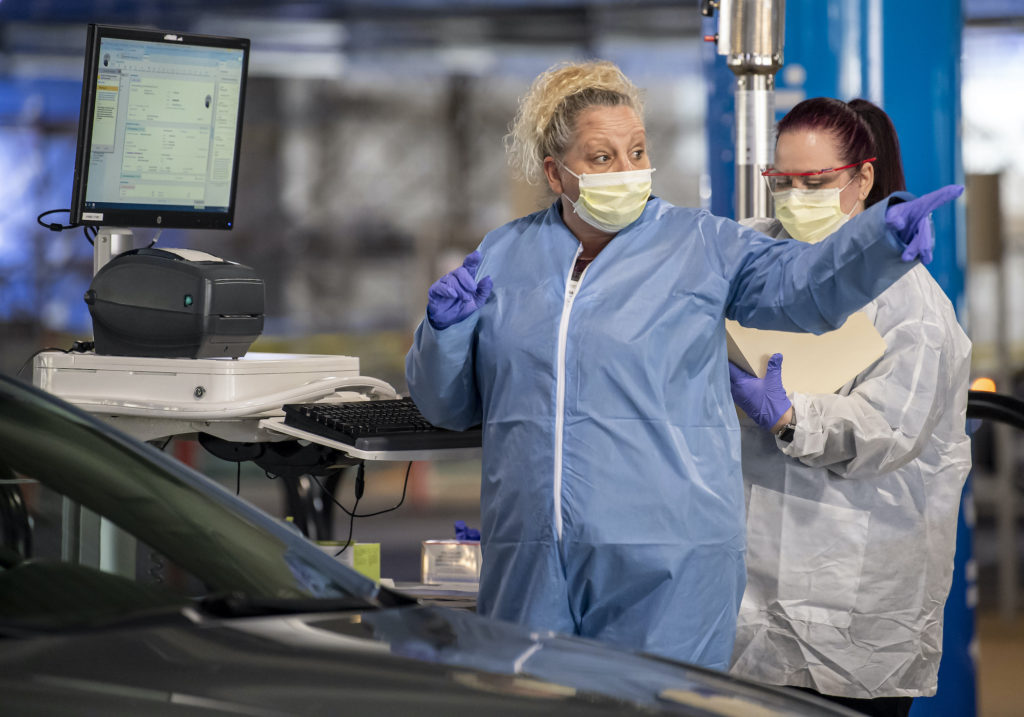Clinical staff workers conduct a drive-through COVID-19 test Wednesday, March 18, 2020, at Allegheny Health Network's Wexford Health + Wellness Pavilion in Wexford, Pa. (Steph Chambers/Pittsburgh Post-Gazette via AP Photo)
