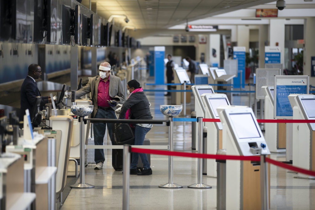 Virus Outbreak Pennsylvania Passengers wearing face masks check in at Philadelphia International Airport in Philadelphia, Thursday, March 19, 2020. (Matt Rourke/AP Photo)