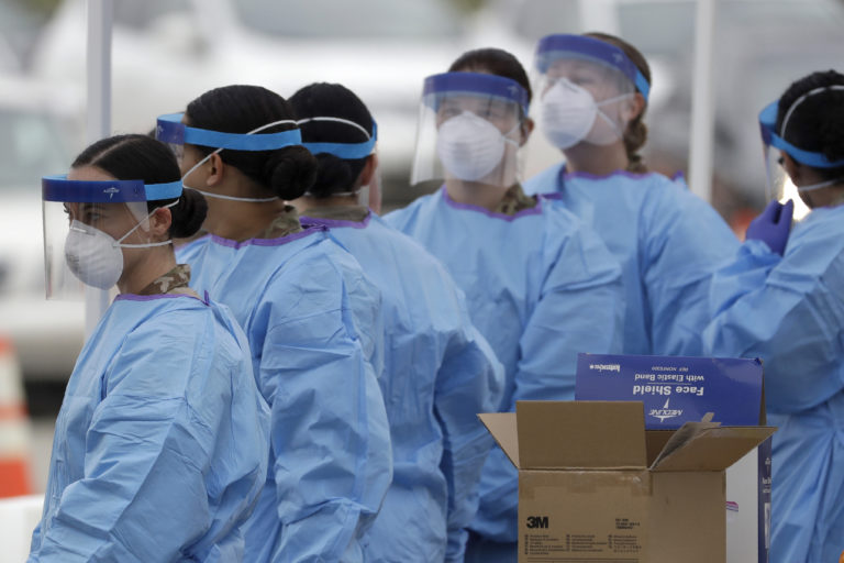 Medical staff prepare to start working at a drive-through testing center for COVID-19 in Paramus, N.J., on Friday, March 20, 2020. (AP Photo/Seth Wenig)