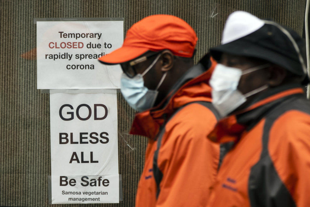Virus Outbreak Pennsylvania Pedestrians in protective face mask walk past a closed business in Philadelphia, Friday, March 20, 2020. (Matt Rourke/AP Photo)
