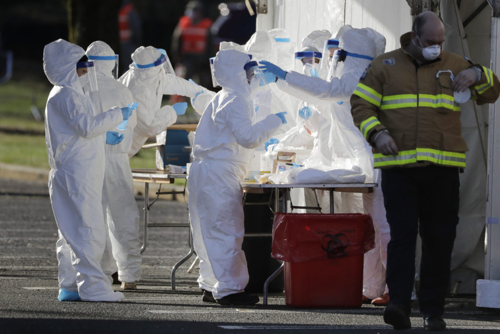 Virus Outbreak New Jersey Staff in protective gear prepare to test people at a drive-through COVID-19 testing site at the PNC Bank Arts Center in Holmdel, N.J., Tuesday, March 24, 2020. (AP Photo/Seth Wenig)