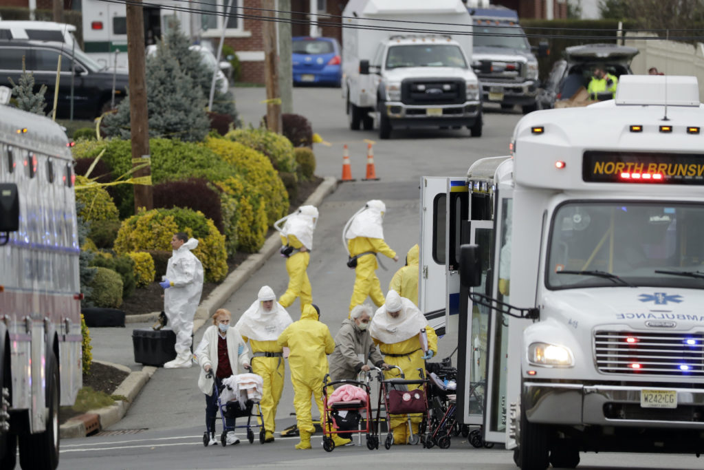 Residents from St. Joseph's Senior Home are helped on to buses in Woodbridge, N.J., Wednesday, March 25, 2020. (Seth Wenig/AP Photo)