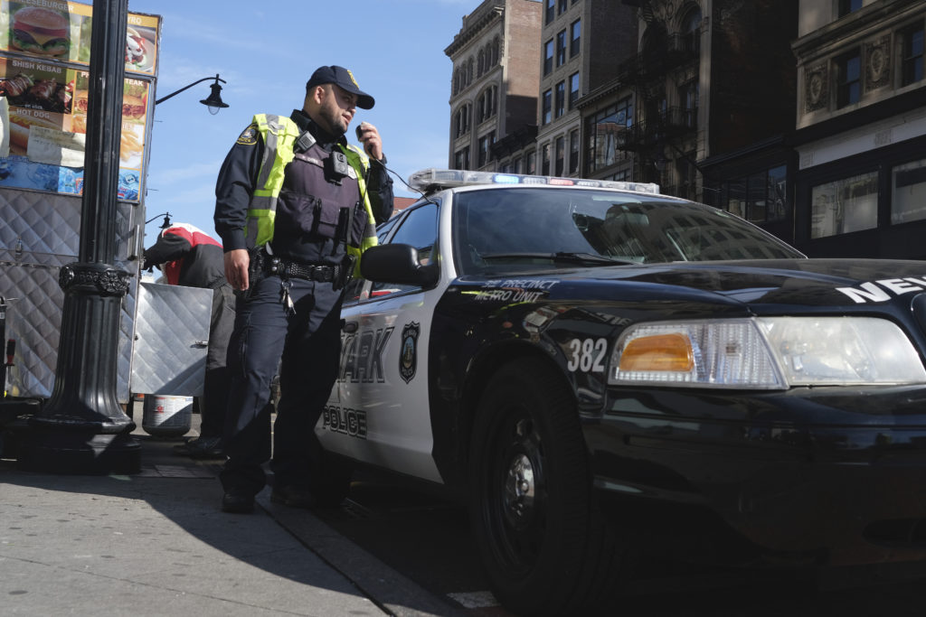 Virus Outbreak Enforcing Social Distance A Newark police officer uses his car megaphone to encourage social distancing at an intersection in Newark, N.J., Thursday, March 26, 2020. (AP Photo/Seth Wenig)
