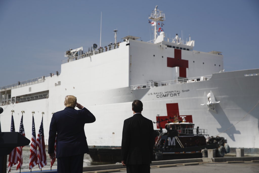 President Donald Trump salutes as the U.S. Navy hospital ship USNS Comfort pulls away from the pier at Naval Station Norfolk in Norfolk, Va. (Patrick Semansky/AP Photo)