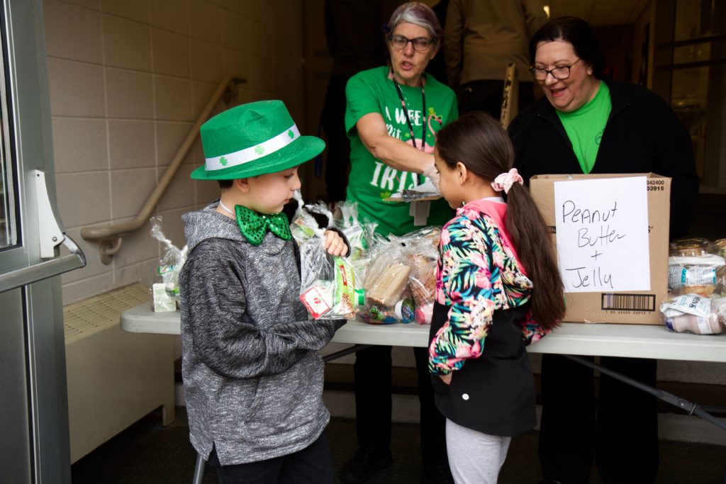 Image from iOS (19) Gavin Holloman, 7, and Taylor Blake choose lunch and breakfast meals at the Bancroft School amid school shutdowns. (Kimberly Paynter/WHYY)