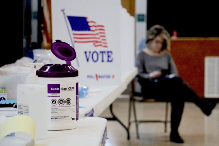 Poll worker Dina Sebold waits for voters at Cecelia Snyder Middle School in Bensalem during a special election for a vacant seat in the Pennsylvania House of Representatives. Hand sanitizer and wipes were made available to voters, many of whom brought their own pens. (Emma Lee/WHYY)
