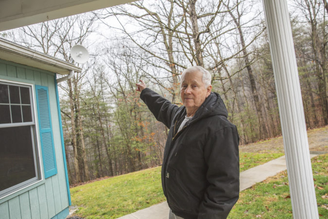 Ken Diven, a founding member of the cooperative and an early user of its service, points to the radio receiver at his home. It picks up signal from the radio tower and connects to a router inside. (Min Xian/Keystone Crossroads)
