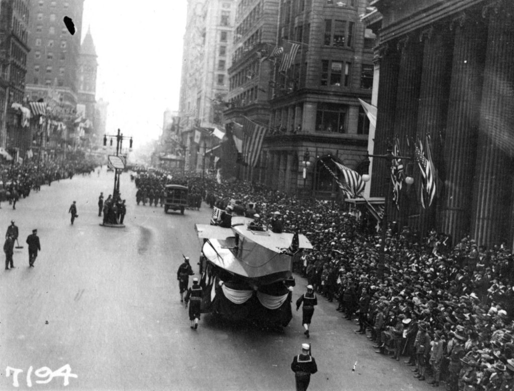 NH 41730 courtesy of the Naval History & Heritage Command A Naval Aircraft Factory float, featuring the hull of a F5L patrol seaplane, heads south on Broad Street in Philadelphia, escorted by sailors with rifles. Note the crowd of onlookers. This parade, with its associated dense gatherings of people, contributed significantly to the massive outbreak of influenza which struck Philadelphia a few days later. (NH 41730 courtesy of the Naval History & Heritage Command)