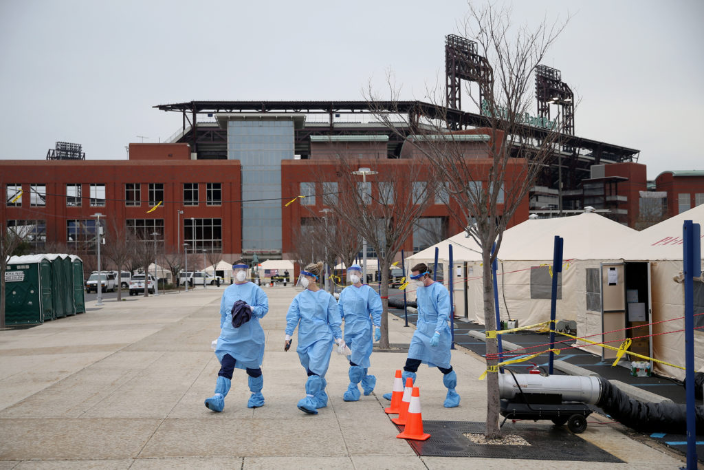 SOUTHPHILLY21-m Philadelphia Medical Reserve Corps volunteers (from left) Megan Boyle, Marina Spitkovskaya, Jamie Huot, and Stephen Bonett, all of whom are nurses, walk to the swabbing tent as the city's coronavirus testing site prepared to open next to Citizens Bank Park in South Philadelphia on Friday, March 20, 2020. (Tim Tai/The Philadelphia Inquirer)