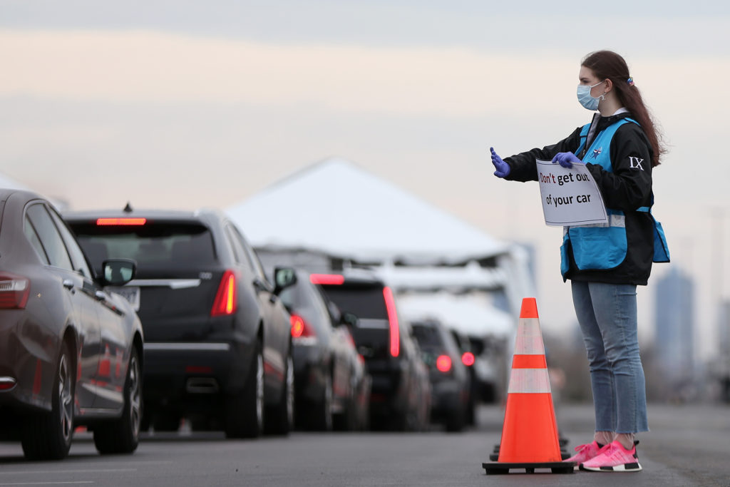 SOUTHPHILLY21-gg Philadelphia Medical Reserve Corps volunteer Emma Ewing, a sophomore at Temple University, directs cars at the city's coronavirus testing site next to Citizens Bank Park in South Philadelphia on Friday, March 20, 2020. (Tim Tai/The Philadelphia Inquirer)