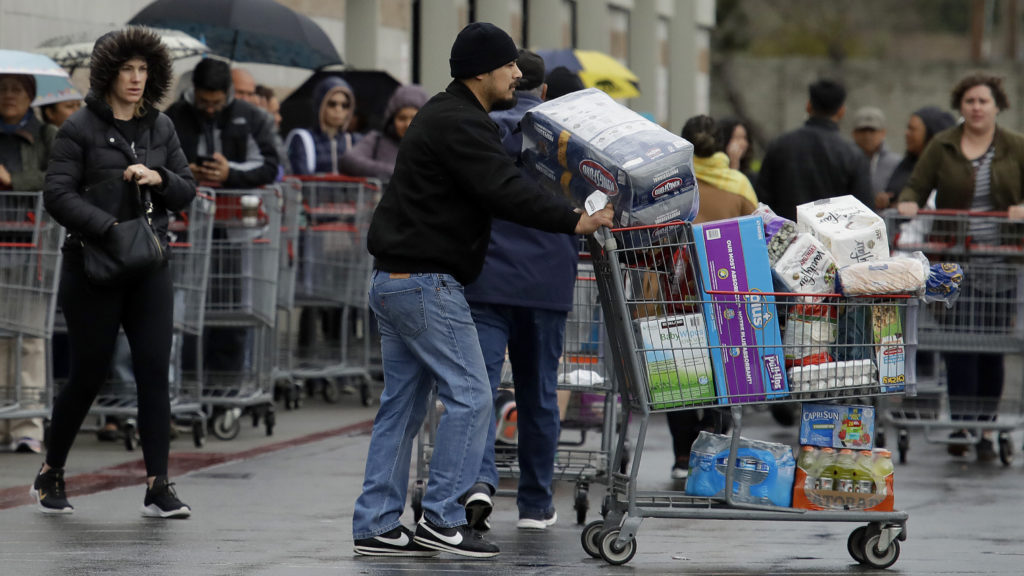Costco customers roll groceries to their cars as others wait to enter the store on March 14 in San Leandro, Calif. Costco customers roll groceries to their cars as others wait to enter the store on March 14 in San Leandro, Calif. (Ben Margot/AP Photo)
