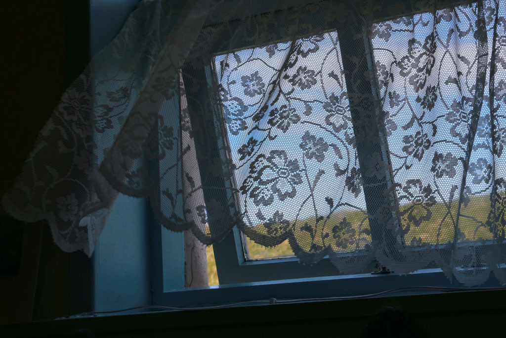 Old-fashioned lace curtain blowing in an open window, closeup (Bigstock/heller760)