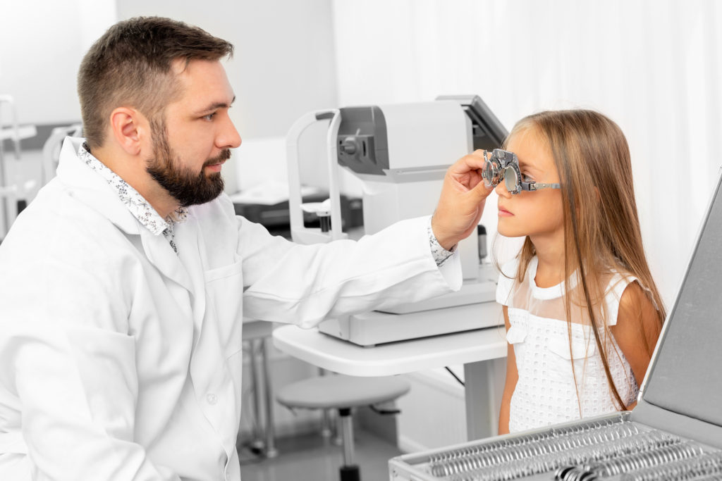 Doctor ophthalmologist holding special eye equipment examinating girl’s eyes in the clinic (LGreen/BigStock)