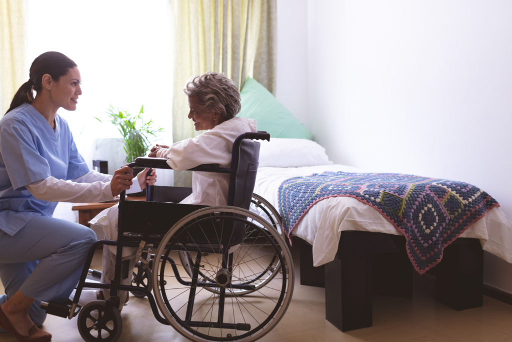 Side view of mixed race nurse talking with senior mixed race fem (Wavebreak Media Ltd/Bigstock)