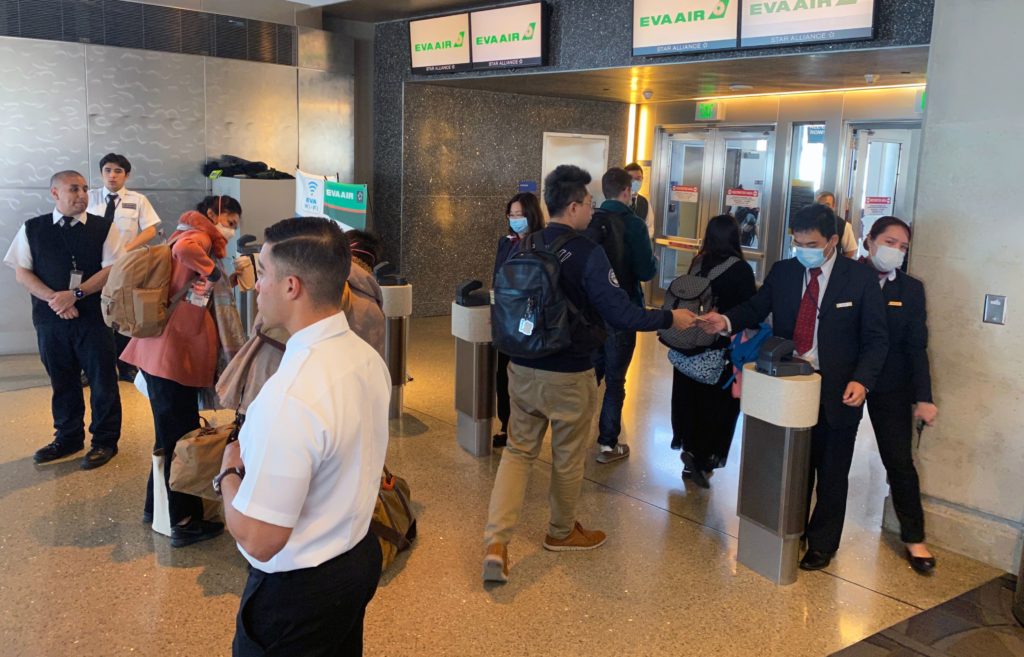 Humans — workers and flight crews as well as passengers — can be exposed to any number of pathogens at airports. EVA Air employees are seen wearing face masks at the Los Angeles airport in February amid the coronavirus outbreak. U.S. officials advise masks are not the best way to mitigate one’s risk of contracting the virus. Humans — workers and flight crews as well as passengers — can be exposed to any number of pathogens at airports. (Daniel Slim/AFP via Getty Images)