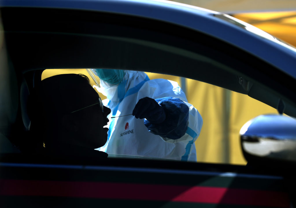 After an initial verbal screening, one driver at a time gets a COVID-19 nasal swab test from a garbed health worker at a drive-up station in Daly City, Calif. After an initial verbal screening, one driver at a time gets a COVID-19 nasal swab test from a garbed health worker at a drive-up station in Daly City, Calif. (Justin Sullivan/Getty Images)