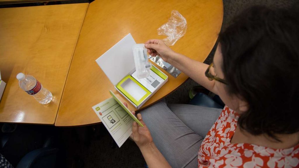 image-5120-1024×576 Dr. Allison Kolpas, a professor in the math department at West Chester University, opens her DNA testing packet. (Emily Cohen for WHYY)