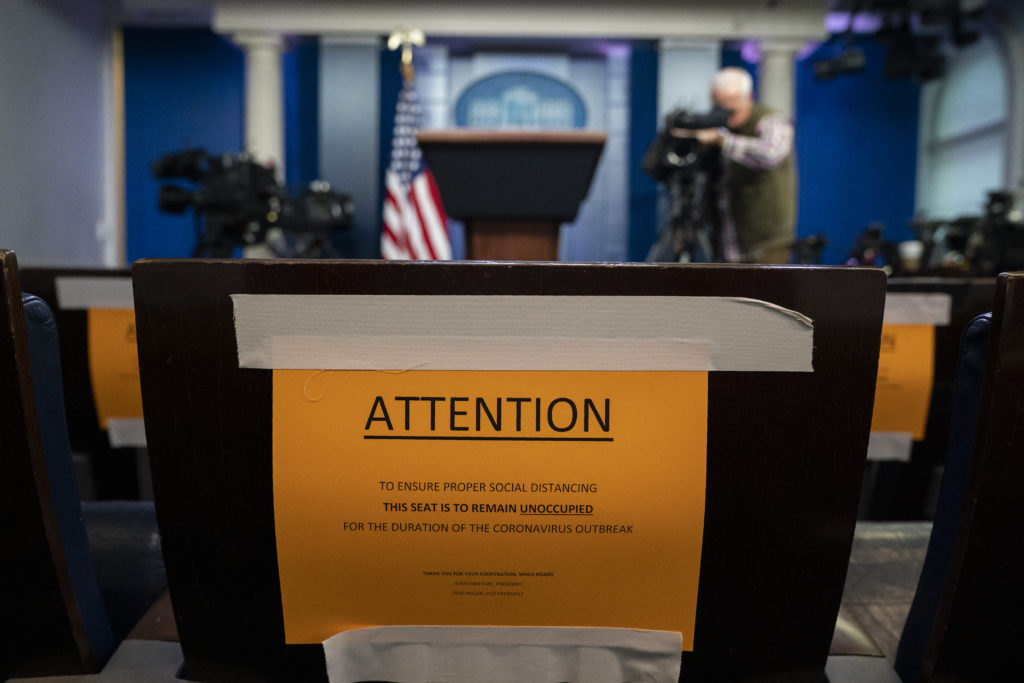 Trump Virus Outbreak Signs in the briefing room of the White House indicate social distancing measures being taken to separate reporters working at the White House, Monday, March 16, 2020, in Washington. (AP Photo/Evan Vucci)