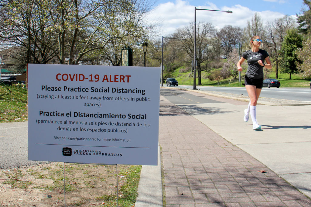 2020 04 02-e lee-philadelphia fairmount park-social distancing- Signs posted along Philadelphia's Schuylkill River Trail caution users to keep six feet away from others to prevent the spread of COVID-19. (Emma Lee/WHYY)
