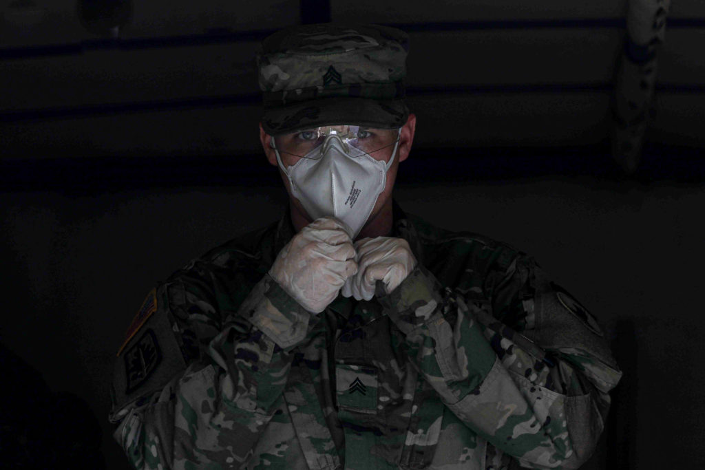 News 2020 – APR 08 – Delaware National Guard assist appoquinimink school district with meal deliveries to the district underserved community. Delaware National Guard Sergeant Whitlock readies himself to deliver packaged food from a medium tactical vehicle on Wednesday, April 8, 2020, at Frederick Lodge Manufactured Home Community in Townsend, Del. (Saquan Stimpson for WHYY)