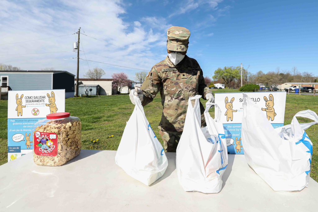 News 2020 – APR 08 – Delaware National Guard assist appoquinimink school district with meal deliveries to the district underserved community. A Delaware National Guard Private Kyeremen sets up a station for packaged food pick-up on Wednesday, April 08, 2020, at Frederick Lodge Manufactured Home Community in Townsend, Del. (Saquan Stimpson for WHYY)
