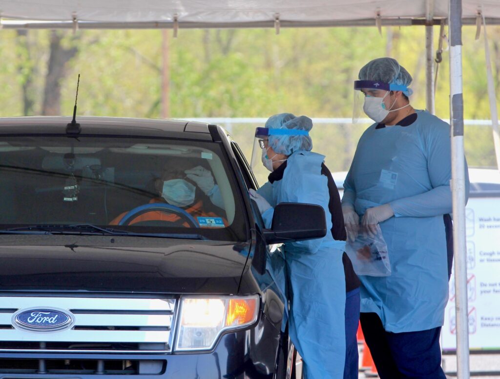 2020 04 29-e lee-camden nj-covid testing site A medical technician performs a nasal swab on a patient at Camden's drive-through testing center at 2600 Mt. Ephraim Ave. (Emma Lee/WHYY)