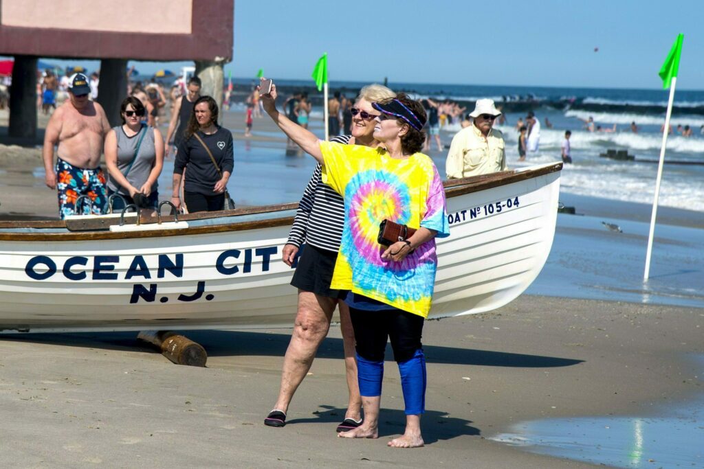 Jeanne Landgraf (left) of Mayfair, in Philadelphia, and Liz Thomsen (right) from Bailey, Colorado, shoot a selfie on the beach in Ocean City on May 27, 2019. (Tom Gralish/The Philadelphia Inquirer via AP)