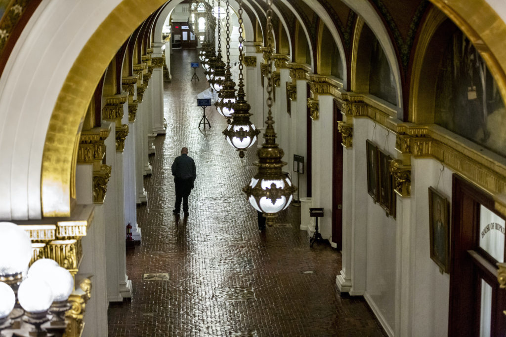 Pa. House of Representatives vote remotely for first time in history House of Representatives security officer Seamus Smith walks the hall after the morning session on Tuesday, March 24, 2020 in Harrisburg, Pa. (Joe Hermitt/The Patriot-News via AP)