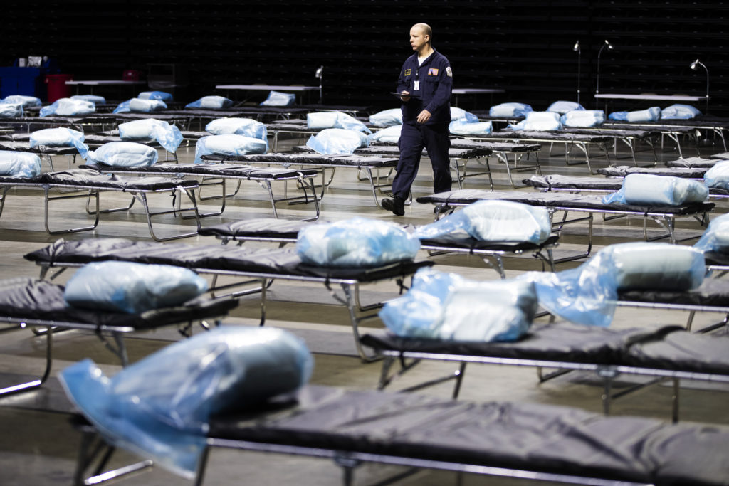 APTOPIX Virus Outbreak Pennsylvania Pennsylvania Task Force 1 member Greg Rogalski walks amongst the beds of a Federal Medical Station for hospital surge capacity set up at Temple University's Liacouras Center in Philadelphia, Monday, March 30, 2020. (AP Photo/Matt Rourke)
