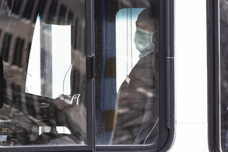 A SEPTA bus driver wears a protective mask as he drives through Philadelphia, Wednesday, April 1, 2020. (AP Photo/Matt Rourke)