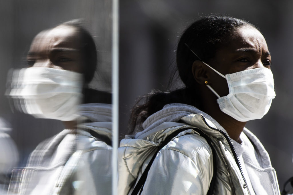 Virus Outbreak Pennsylvania A person wearing protective masks due to coronavirus concerns walks in Philadelphia, Thursday, April 2, 2020. (AP Photo/Matt Rourke)