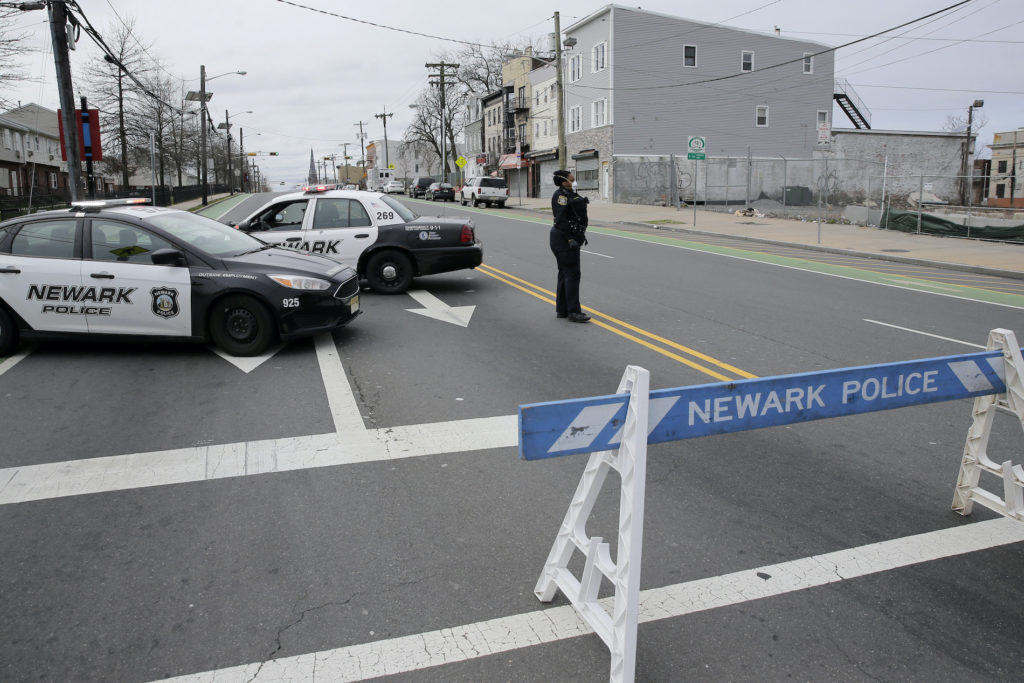 Virus Outbreak A police officer stands at an intersection on the border between Irvington and Newark, N.J., Friday, April 3, 2020. (Seth Wenig/AP Photo)