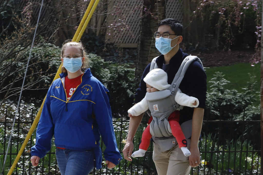 Virus Outbreak Pennsylvania Daily Life A couple out for walk wear protective masks on a warm afternoon in Pittsburgh, Sunday, April 5, 2020. (AP Photo/Gene J. Puskar)