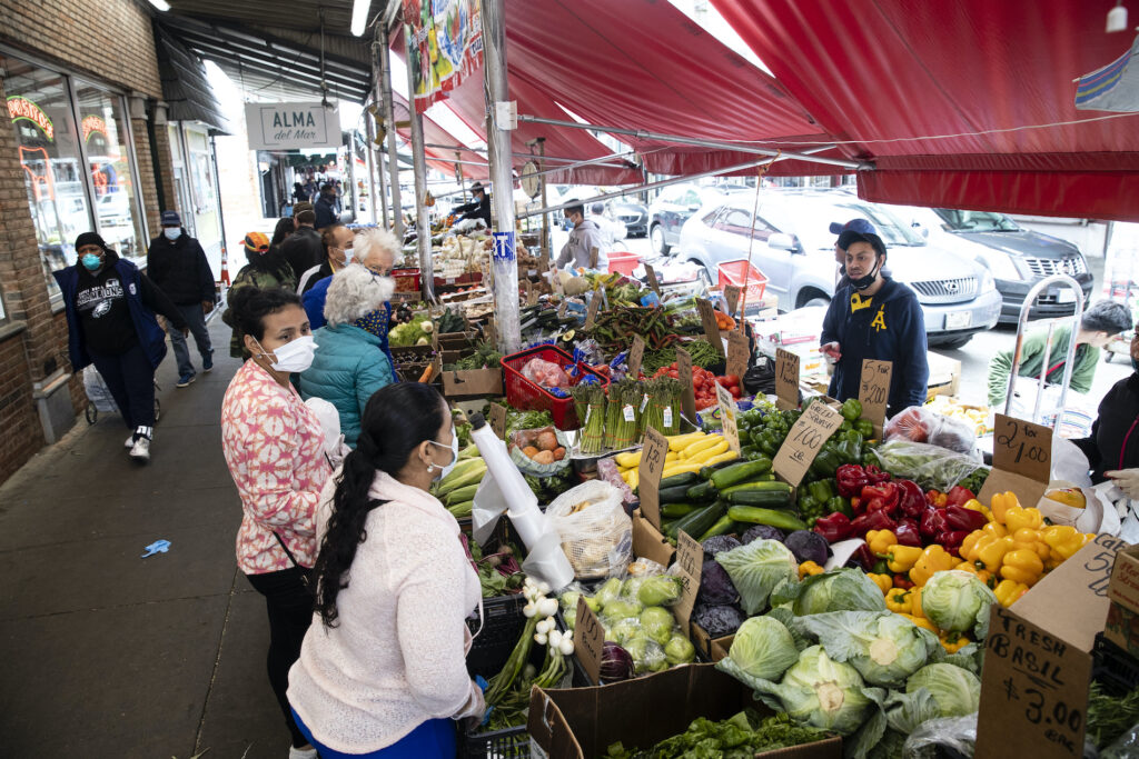 Virus Outbreak Pennsylvania Daily Life Customers wearing face coverings to protect against the spread of the coronavirus, shop at a produce stand on South 9th Street in the Italian Market neighborhood of Philadelphia, Thursday, April 9, 2020. (AP Photo/Matt Rourke)