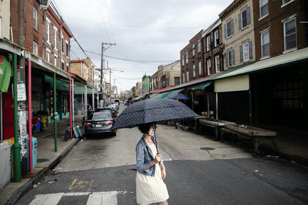 Virus Outbreak Pennsylvania Daily Life A shopper wearing a face mask to protect against the spread of the new coronavirus crosses South 9th Street in the Italian Market neighborhood of Philadelphia, Thursday, April 9, 2020. (AP Photo/Matt Rourke)