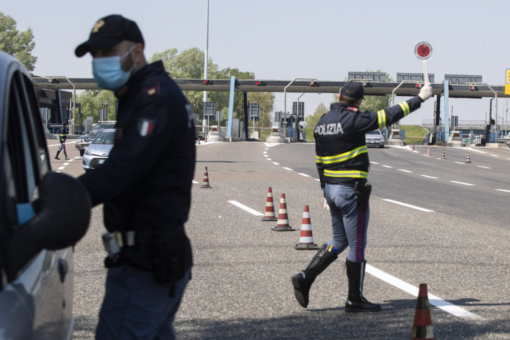Virus Outbreak Easter Italy Police officers stop cars at the Melegnano highway barrier entrance, near Milan, Italy, Saturday, April 11, 2020. (Luca Bruno/AP Photo)