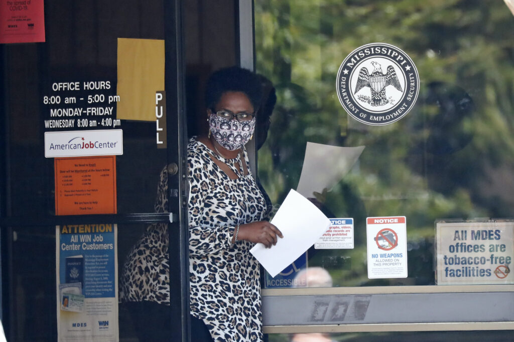 Virus Outbreak Mississippi Unemployment A masked worker at this state WIN job center in Pearl, Miss., holds an unemployment benefit application form as she waits for a client, Tuesday, April 21, 2020. (AP Photo/Rogelio V. Solis)