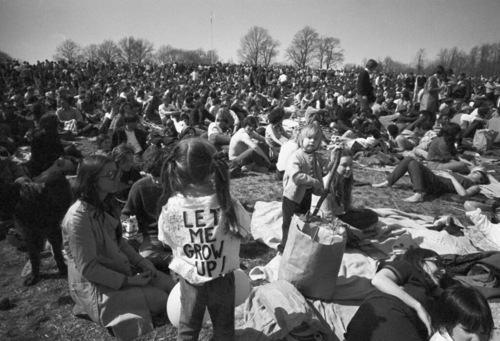 Earth Day Evolution A black-and-white photo shows people gathered in a park.