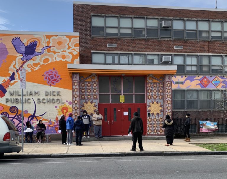 People outside William Dick Elementary School in North Philadelphia wait to pick up Chromebooks.