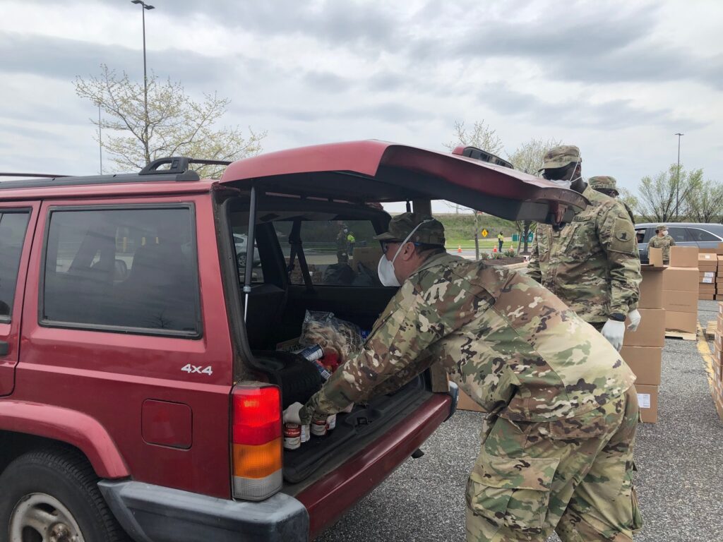 IMG_6861 Brian Turner of the Delaware National Guard places food in a trunk during Monday's giveaway. (Cris Barrish/WHYY)