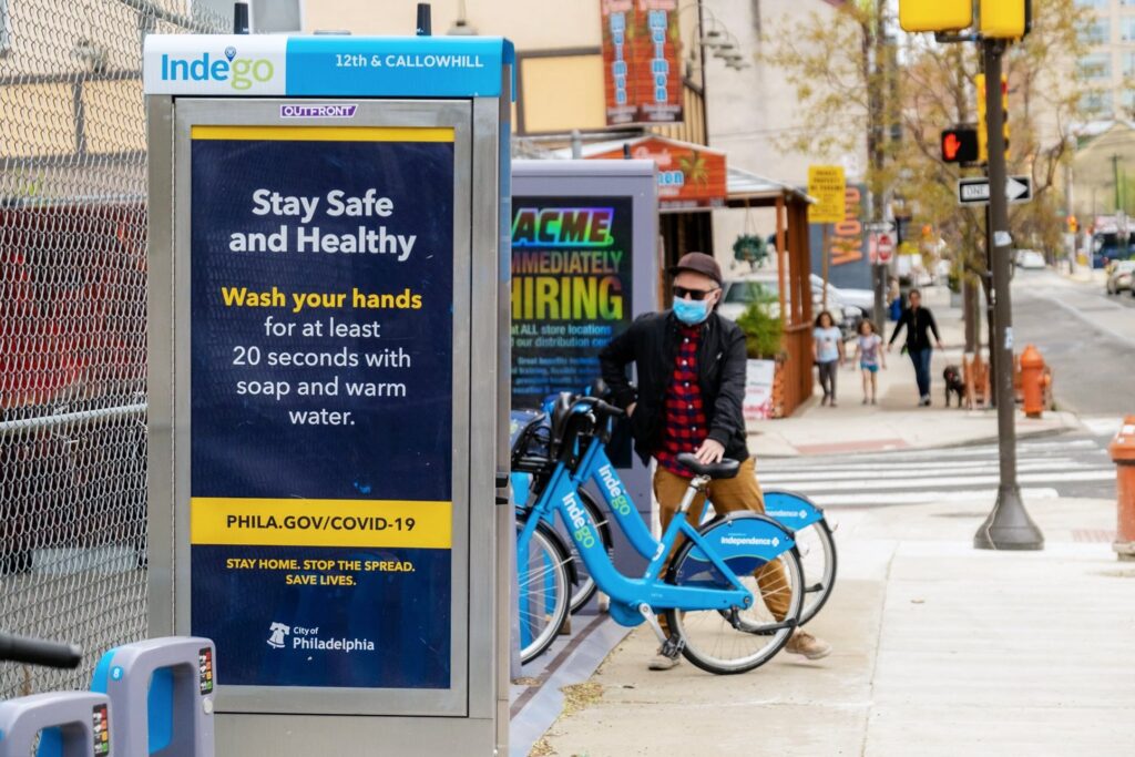 Indego lead art A rider stands next to an Indego station. (Indego/City of Philadelphia)