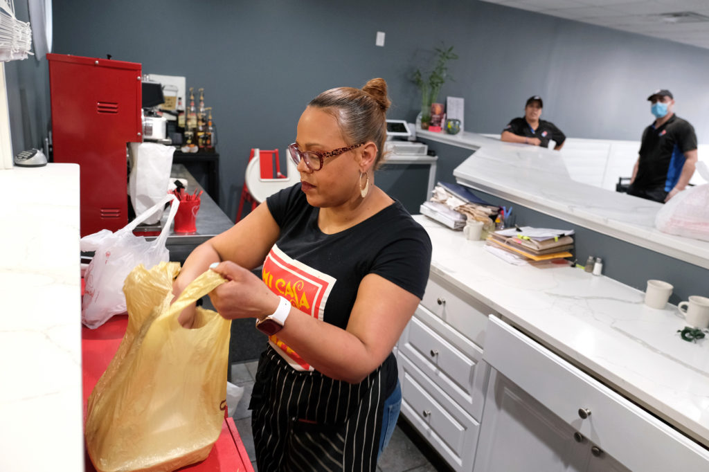 Mi Casa Su Casa Reading 07 Johanny Cepeda-Freytiz bags up food that was ordered ahead of time for pick up on April 3, 2020, at Mi Casa Su Casa cafe in Reading, Pennsylvania. (Matt Smith for Keystone Crossroads)