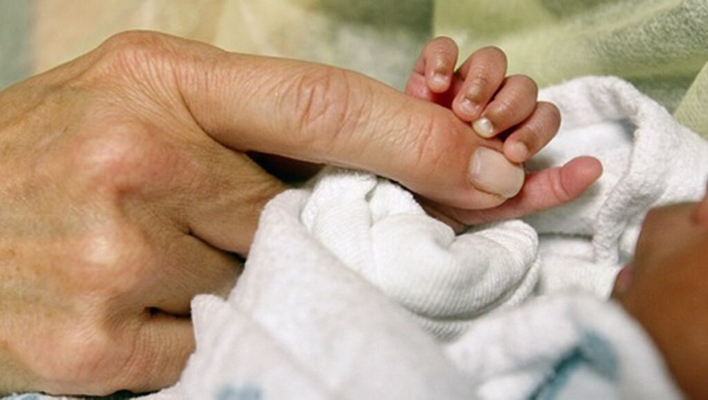 Baby Cuddlers An infant grasps volunteer Kathleen Jones' hand in the neonatal intensive care unit at the University of Chicago's Comer Children's Hospital in Chicago on Wednesday, Feb. 19, 2014. (AP Photo/Martha Irvine)