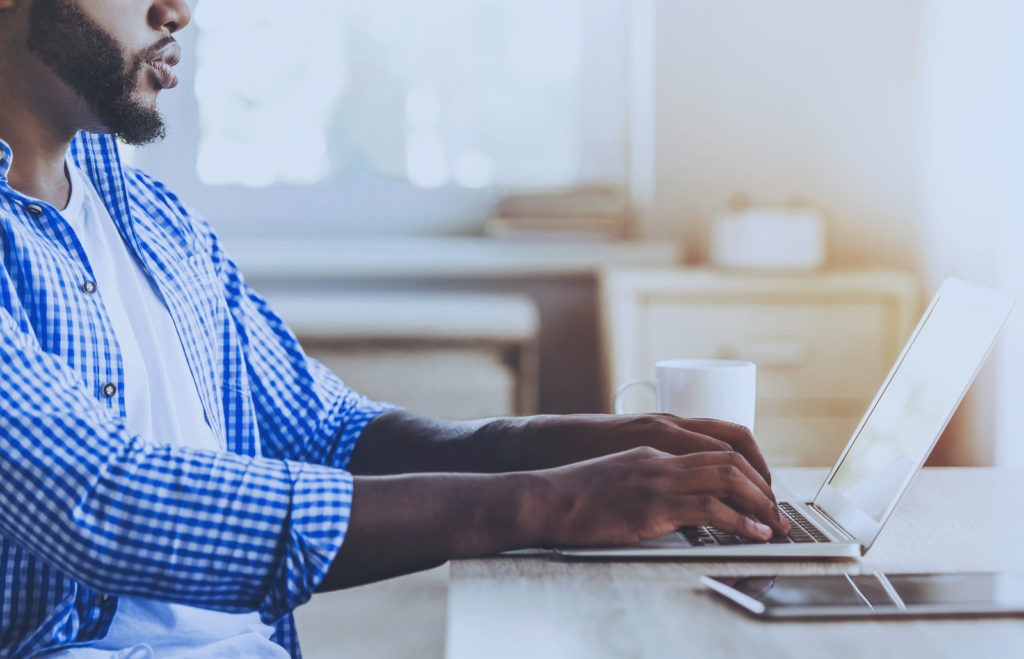 Young Beard Afro-american Man Working With Laptop Sitting At Tab (VadimGuzhva/BigStock)
