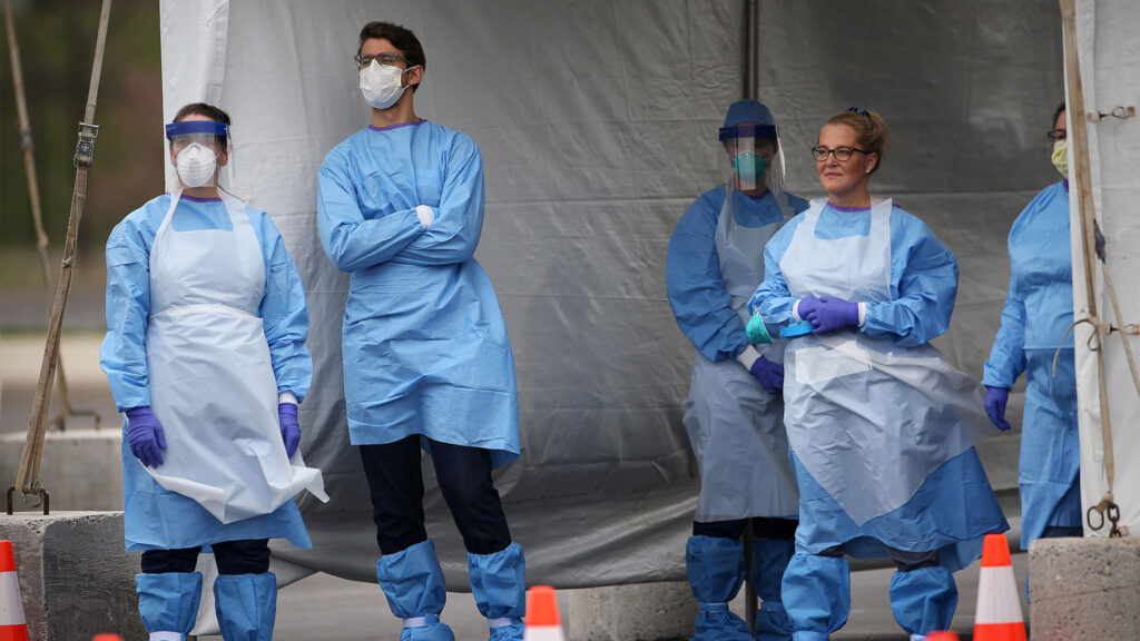 Medical workers wait for cars to pull up to the swabbing tent at the city's coronavirus testing site next to Citizens Bank Park in South Philadelphia on Friday, March 20, 2020. (Tim Tai/The Philadelphia Inquirer via Pool)